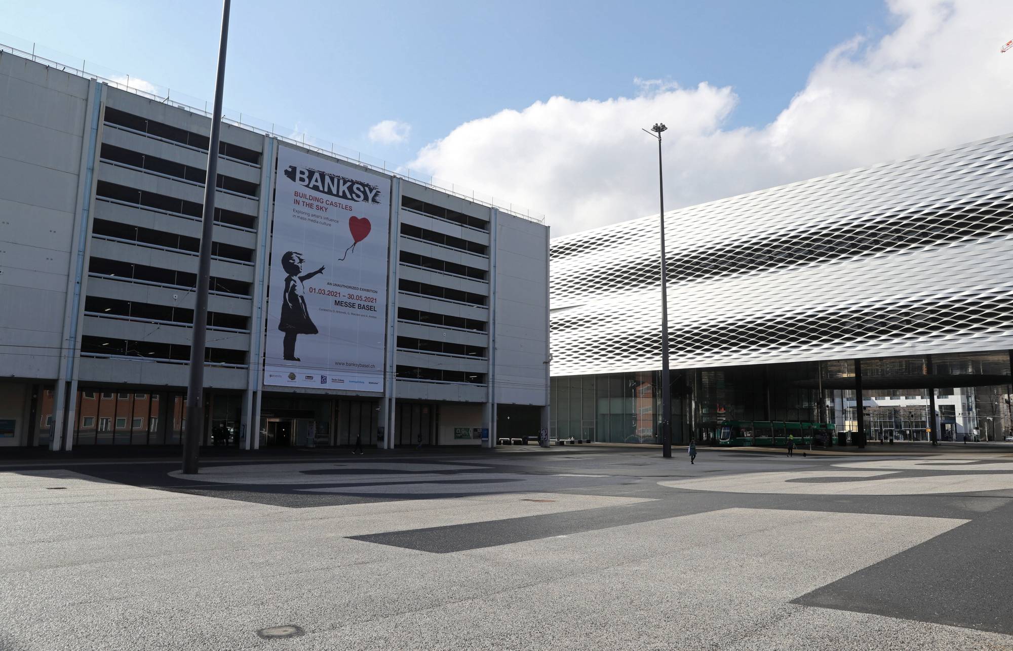 A poster promotes an exhibition of works by artist Banksy at the Messe Basel fairground at Messeplatz square in Basel, Switzerland, on March 18. | Reuters 