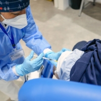 A health worker administers a COVID-19 vaccine in Rome on Wednesday.  | BLOOMBERG 