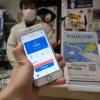 A store selling school uniforms in Kisarazu, Chiba Prefecture, accepts Aqua Coin, a local digital currency used in the city. | KAZUAKI NAGATA
