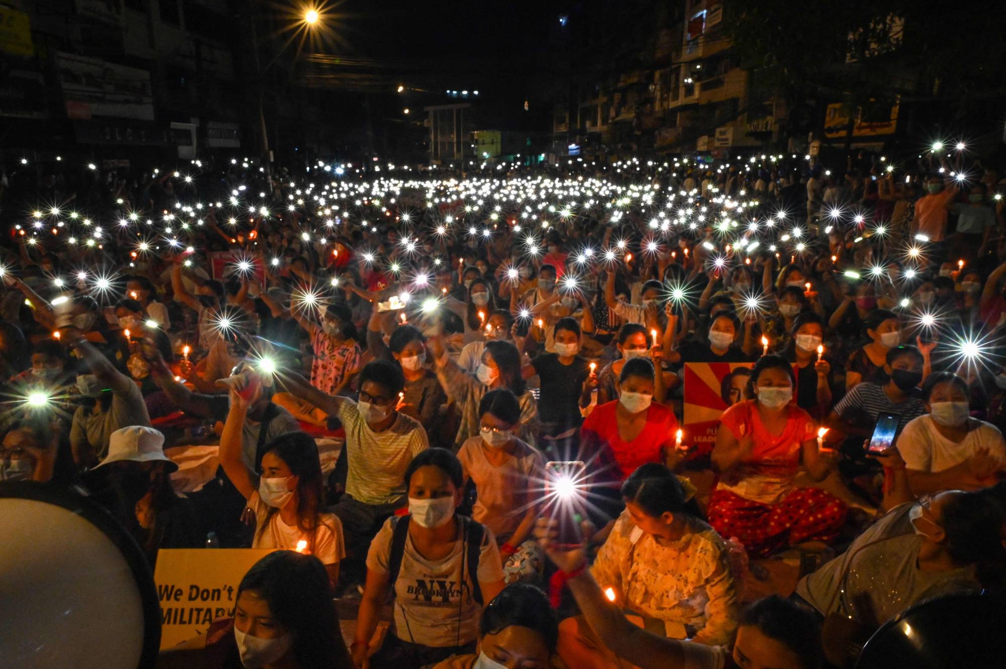 Protesters hold up their mobile phones as they take part in a candlelight vigil to honor those who have died during demonstrations against the military coup, in Yangon on March 13. | AFP-Jiji