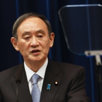 Prime Minister Yoshihide Suga speaks during a news conference in Tokyo on March 18. | BLOOMBERG