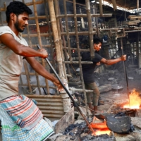 Bangladeshi laborers work at a factory where they make various machinery parts from melted metals, in Dhaka on Feb. 13. | REUTERS