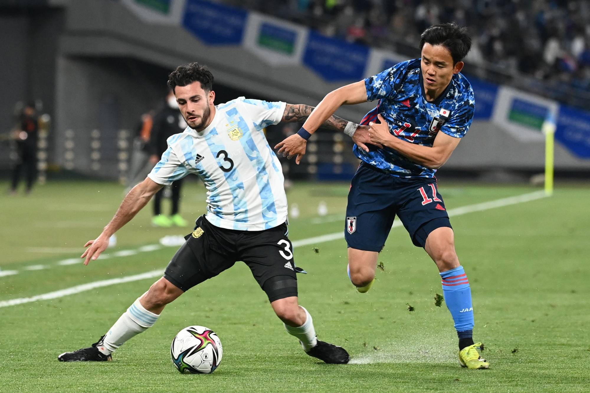 Japan midfielder Takefusa Kubo (right) and Argentina defender Milton Valenzuela fight for the ball during their under-24 international friendly at Ajinomoto Stadium on Friday. | AFP-JIJI