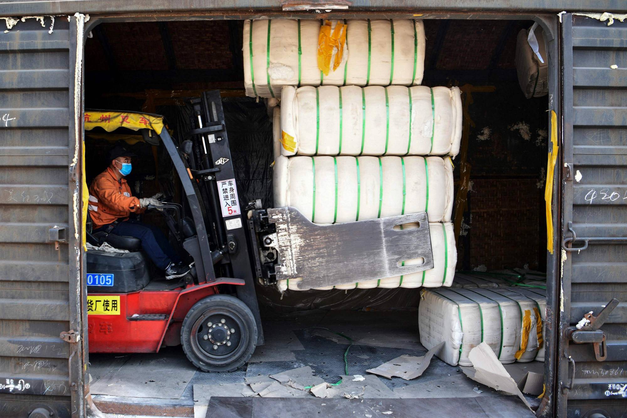 A worker unloads cotton picked from Xinjiang at a railway station in Jiujiang, in China's central Jiangxi province, on Friday.  | AFP-JIJI