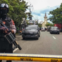 An Indonesian policeman stands guard after an explosion outside a church in Makassar on Sunday.  | AFP-JIJI
