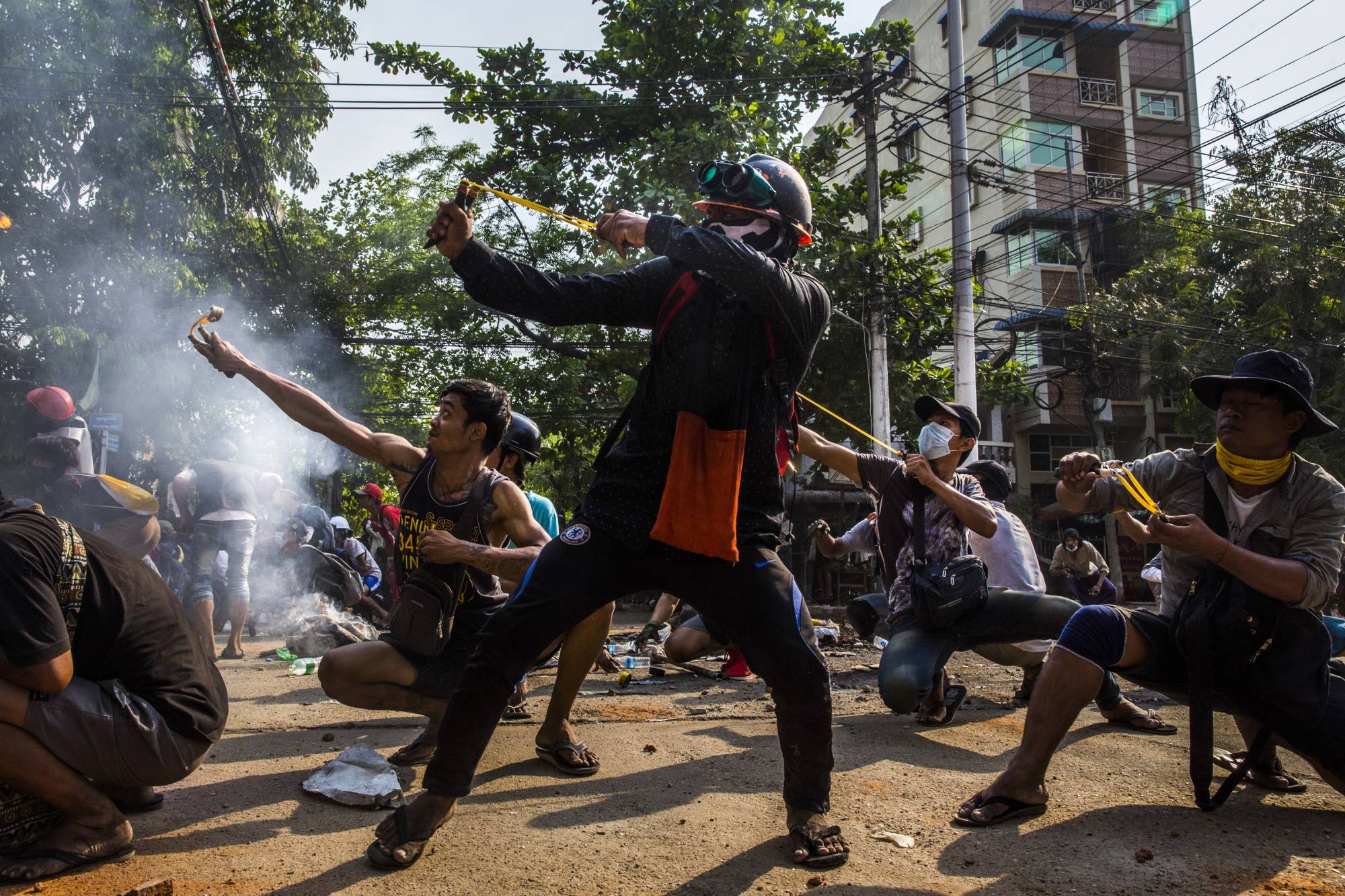 Protesters use slingshots during a clash with security forces in the township of Thaketa in Yangon, Myanmar, on Sunday. | THE NEW YORK TIMES