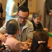 Jun Sasaki, a doctor and the head of Yushokai Medical Corp., a home medical care provider, examines a patient. | COURTESY OF YUSHOKAI MEDICAL CORP.

