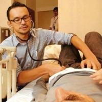 Jun Sasaki, a doctor and the head of Yushokai Medical Corp., a home medical care provider, examines a patient. | COURTESY OF YUSHOKAI MEDICAL CORP.