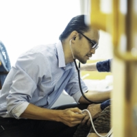 Jun Sasaki, a doctor and the head of Yushokai Medical Corp., a home medical care provider, examines a patient. | HIROSHI HATANO
