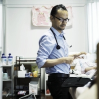 Jun Sasaki, a doctor and the head of Yushokai Medical Corp., a home medical care provider, examines a patient. | HIROSHI HATANO
