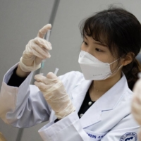 Nurses prepare doses of the Pfizer-BioNTech COVID-19 vaccine in Goyang, South Korea, on Thursday. | BLOOMBERG 