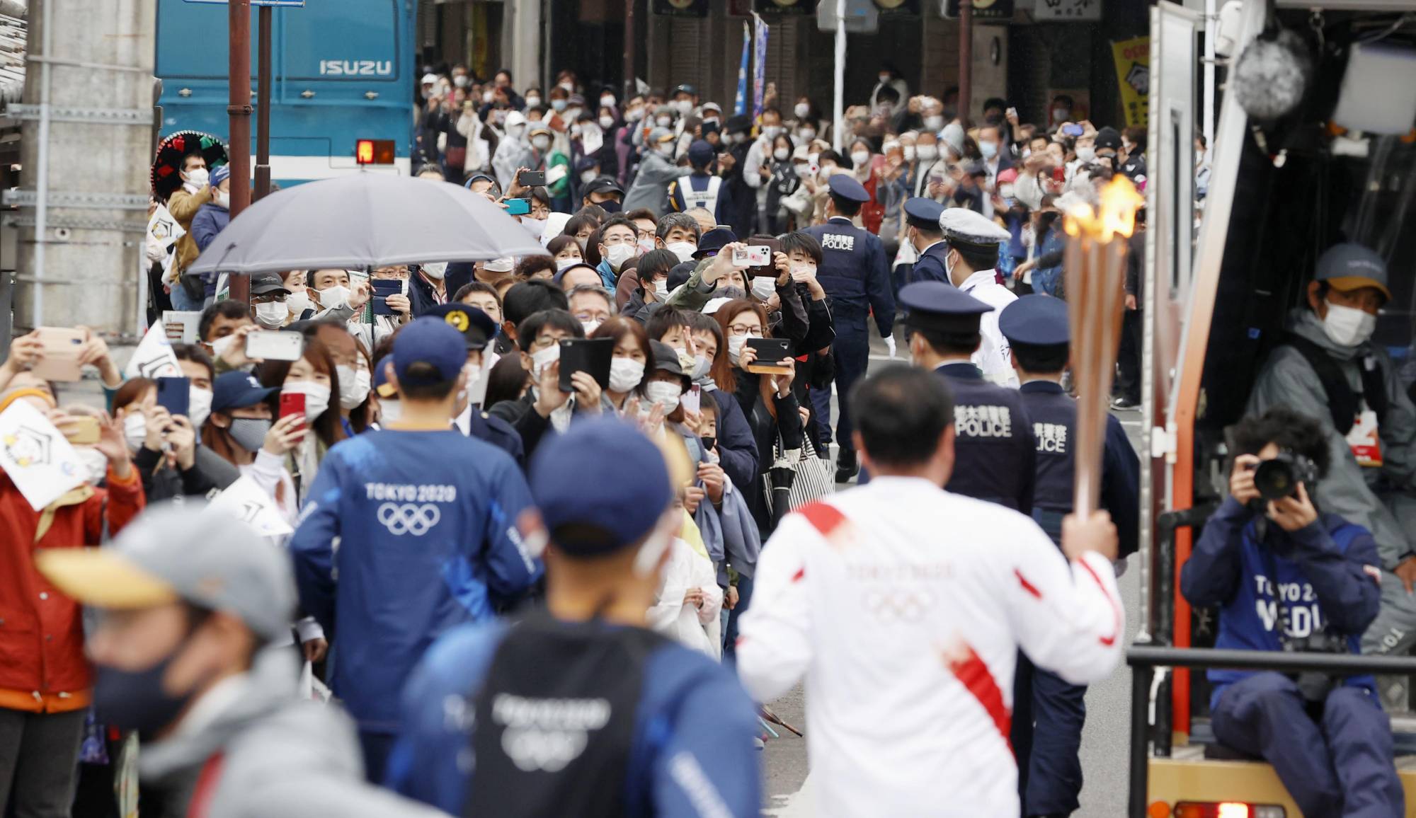 Crowds gather to watch a Tokyo Olympic torchbearer run through the city of Tochigi on Sunday. | KYODO