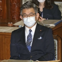 Communications minister Ryota Takeda attends the Lower House plenary session on Thursday, where a no-confidence motion against him was rejected. | KYODO