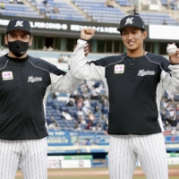 Marines pitcher Fumiya Motomae (right) celebrates with manager Tadahito Iguchi after recording the first win of his career in Chiba on Thursday.  | KYODO