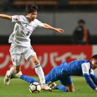 Sho Inagaki (left) contends for the ball with Mongolia\'s Amaraa Dulguun during a World Cup qualifier in Chiba on Tuesday. | AFP-JIJI