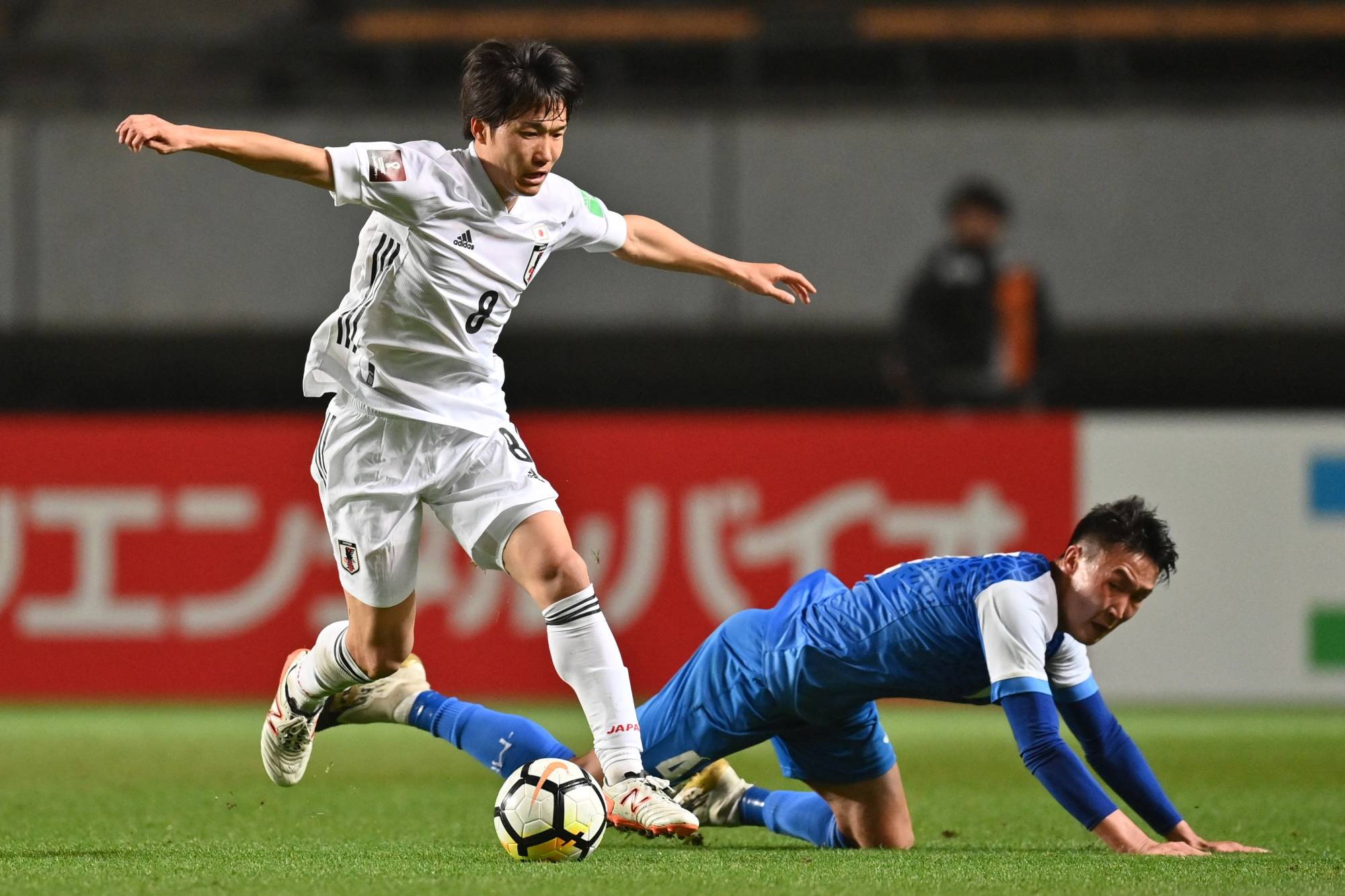 Sho Inagaki (left) contends for the ball with Mongolia's Amaraa Dulguun during a World Cup qualifier in Chiba on Tuesday. | AFP-Jiji