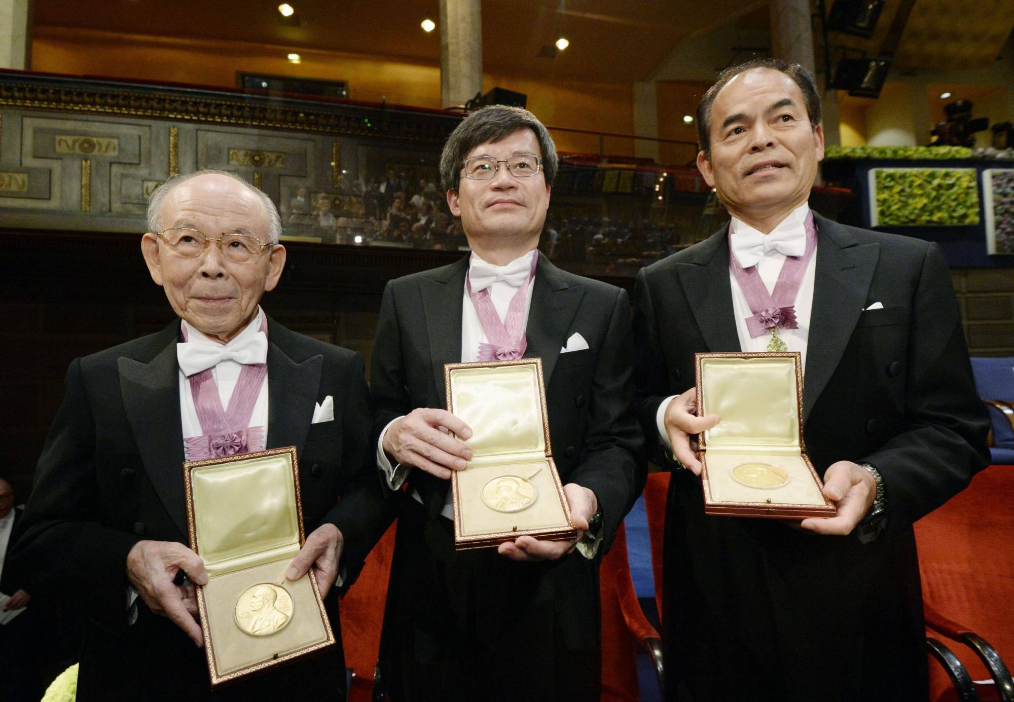 Physicist Isamu Akasaki (left), physicist Hiroshi Amano (center), a professor at the University of Nagoya, and Japan-born American Shuji Nakamura, a professor at the University of California, Santa Barbara, hold their 2014 Nobel Prizes in physics for inventing the world's first efficient blue light-emitting diodes in December of that year in Stockholm.  | KYODO