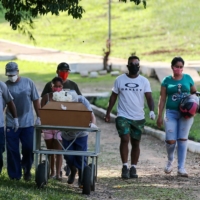 Relatives and gravediggers walk next to the coffin of a woman who died due to COVID-19 during her burial at Campo Santo cemetery in Porto Alegre, Brazil, on Tuesday. | REUTERS