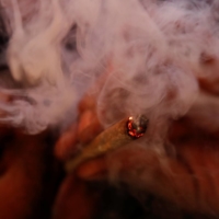 A man smokes cannabis at his home on April 1 in New York, where recreational use of the drug is now legal. | REUTERS