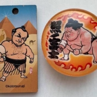 Kototsurugi illustrated countless pieces of merchandise for the Japan Sumo Association, including an Osunaarashi charm (left) and Terunofuji magnet.  | JOHN GUNNING
