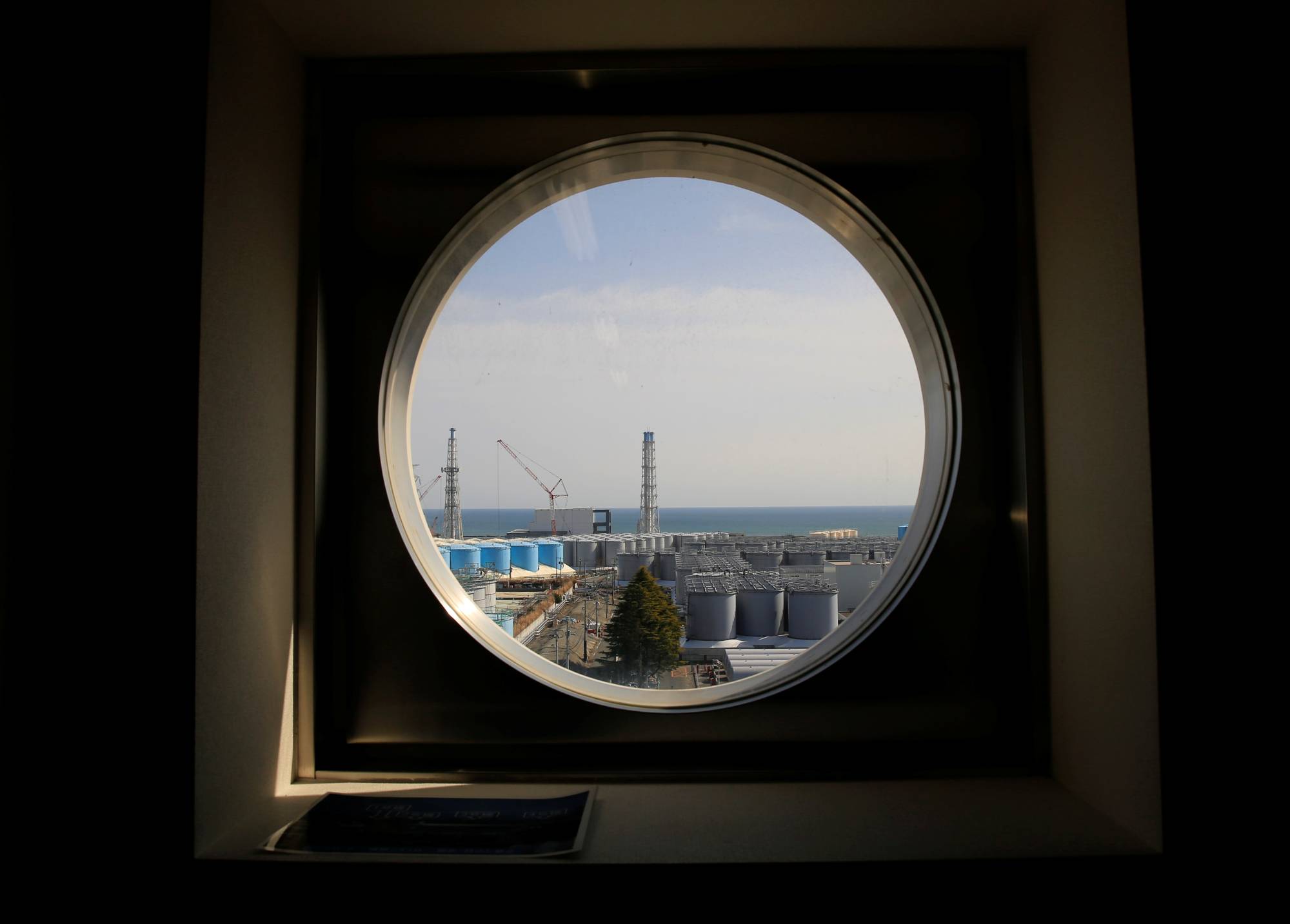 Storage tanks for treated water are seen through a window at the tsunami-crippled Fukushima No. 1 nuclear power plant in Fukushima Prefecture in March. | REUTERS