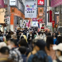 Crowds of people walk on Osaka\'s Tenjinbashisuji shopping street on Wednesday afternoon. | KYODO