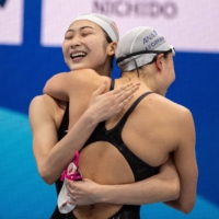 Rikako Ikee (left) hugs Rika Okamoto after her victory in the women\'s 100-meter freestyle final at the national swimming championships at the Tokyo Aquatics Centre on Thursday. | AFP-JIJI