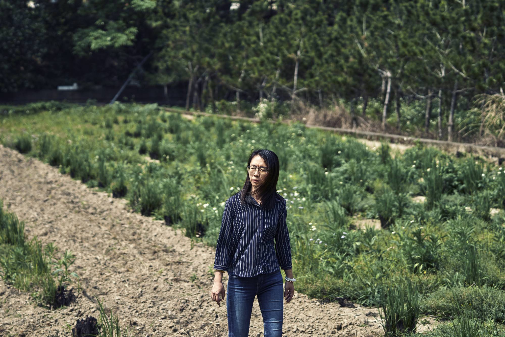 Kuo Yu-ling on a plot of parched land where she and her partner, Chuang Cheng-deng, normally grow rice and vegetables in Hsinchu, Taiwan. | An Rong Xu / The New York Times