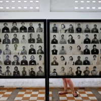 A visitor looks at pictures of victims of Khmer Rouge regime at the former notorious Tuol Sleng prison that is now the Genocide Museum, in Phnom Penh in August 2014.  | REUTERS