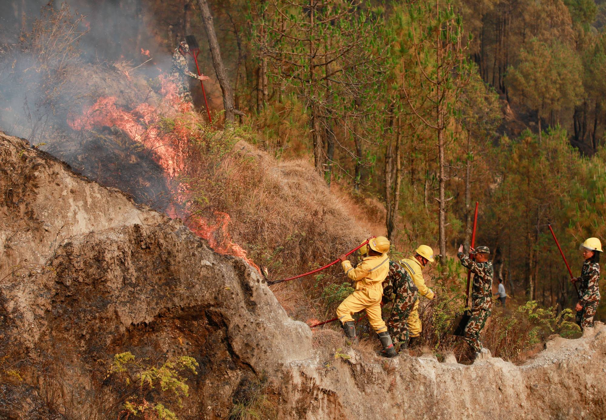 Members of Nepal's army try to control a fire on Sunday at Shivapuri National Park, overlooking Kathmandu, as forest fires have raged many areas in Nepal. | REUTERS 