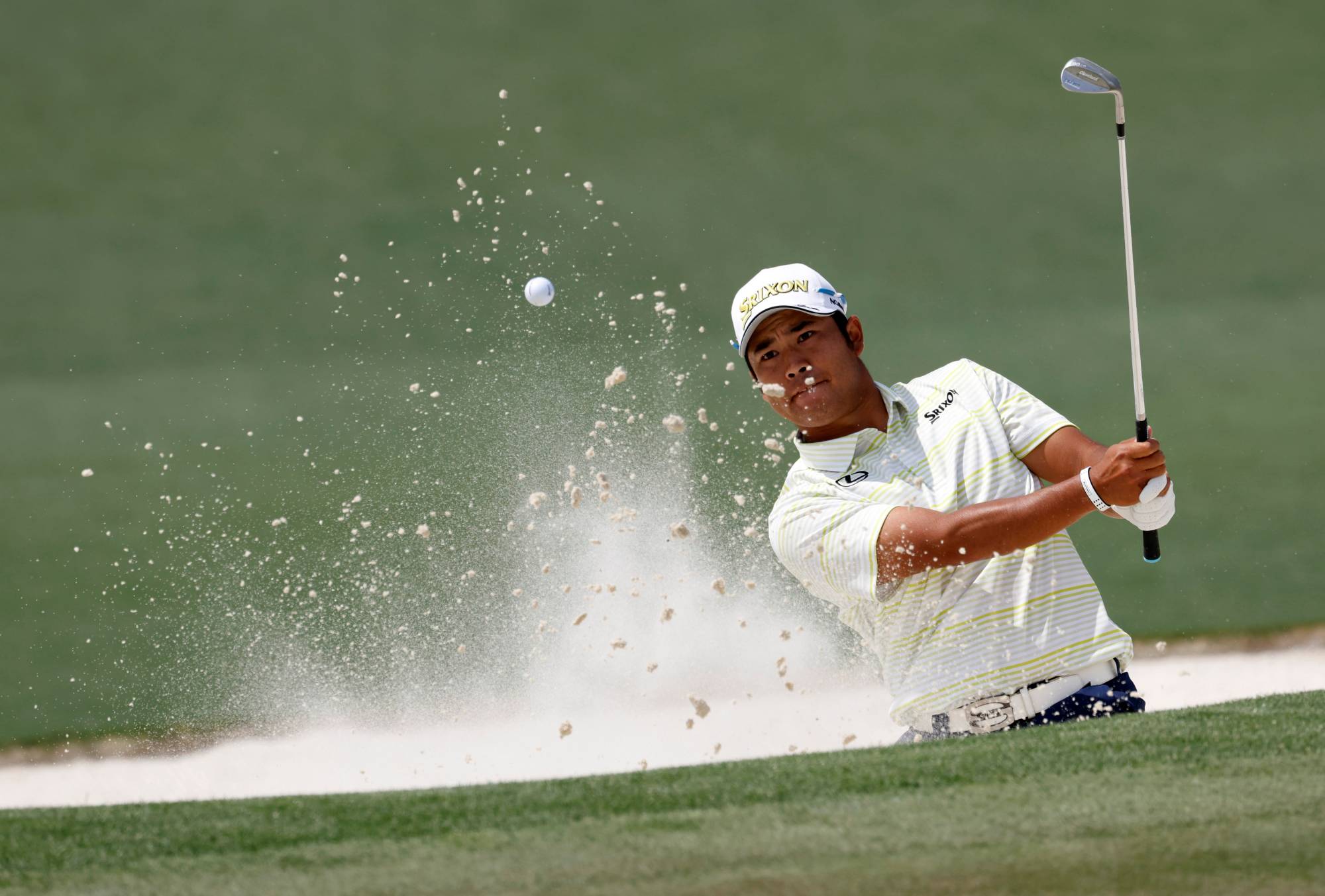 Hideki Matsuyama plays out of a bunker on the second hole during Sunday's final round at Augusta National. | Reuters