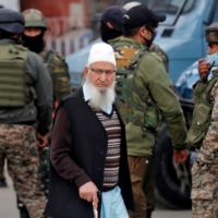 A Kashmiri man walks past Indian security force personnel standing guard during a cordon and search operation in the city of Srinagar, in the region of Jammu and Kashmir, in February. | REUTERS 