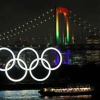 The Rainbow Bridge is illuminated with Olympic colors on Wednesday to mark 100 days until the Olympics. | REUTERS
