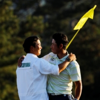 Japan\'s Hideki Matsuyama celebrates with his caddie on the 18th green after winning The Masters in  Augusta, Georgia, on April 11.  | REUTERS