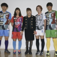 Designer Hiroko Koshino (center) poses with INAC Kobe players during a news conference in Kobe on Thursday. The players are wearing new uniforms that Koshino designed.  | KYODO