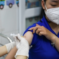 A woman receives a vaccine as Vietnam starts its official rollout of AstraZeneca\'s jabs, in Hai Duong province on March 8.  | REUTERS