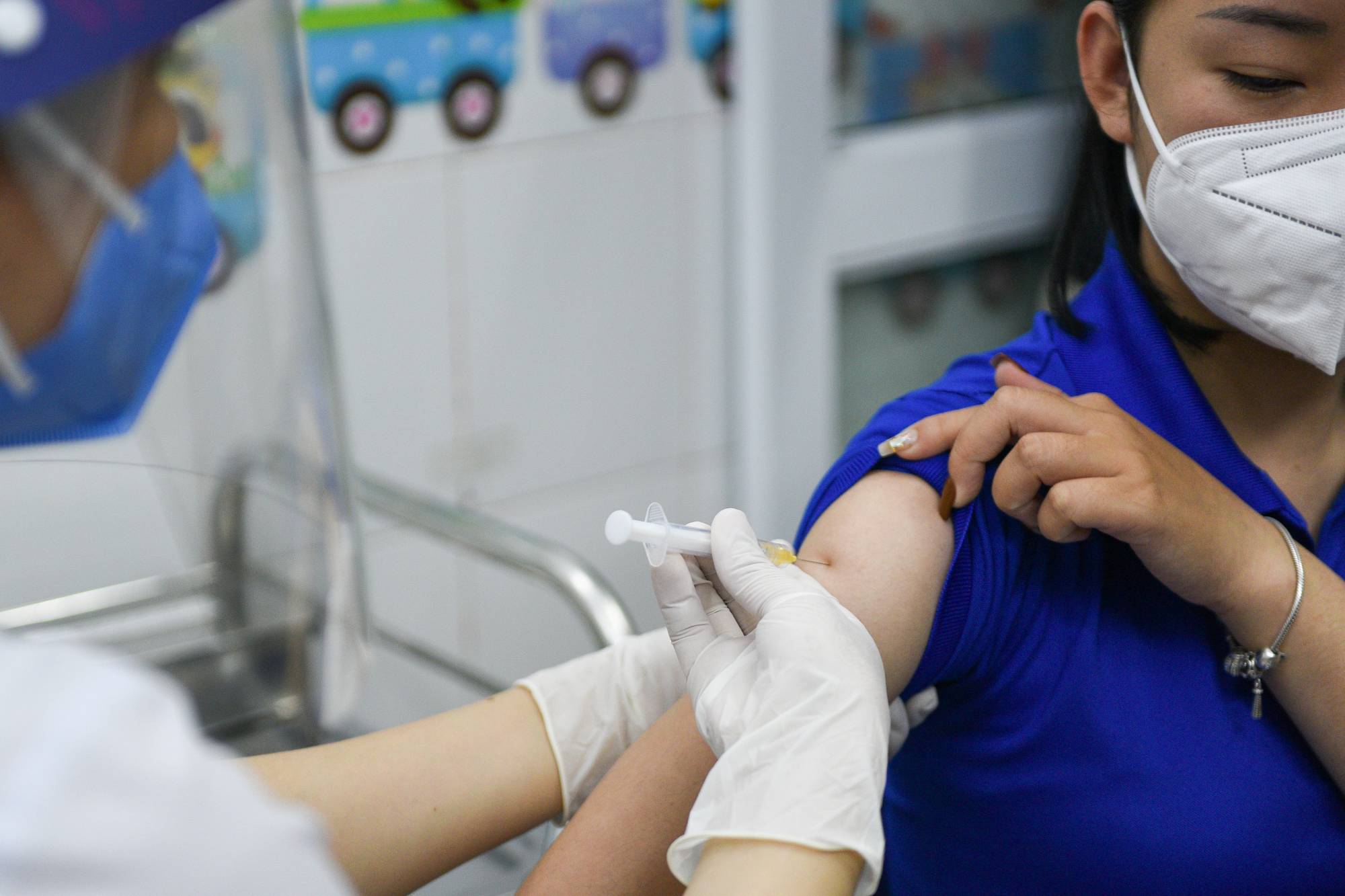 A woman receives a vaccine as Vietnam starts its official rollout of AstraZeneca's jabs, in Hai Duong province on March 8.  | REUTERS