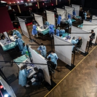 Health workers take swab samples for COVID-19 tests from attendees ahead of a concert in Barcelona.  | BLOOMBERG 