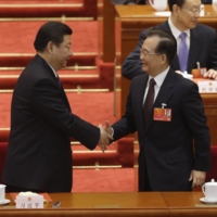 Newly elected Chinese President Xi Jinping and former Premier Wen Jiabao shake hands during a meeting of the National People\'s Congress at Beijing\'s Great Hall of the People in March 2013.  | REUTERS
