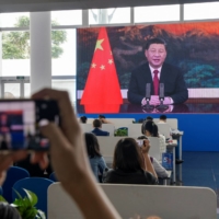Journalists watch a screen showing Chinese leader Xi Jinping delivering a speech during the opening of the Boao Forum for Asia in south China\'s Hainan province on Tuesday. | AFP-JIJI