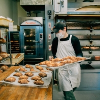 Staff take baked goods out of the oven at Bricolage Bread & Co. in Roppongi. | NATHALIE CANTACUZINO
