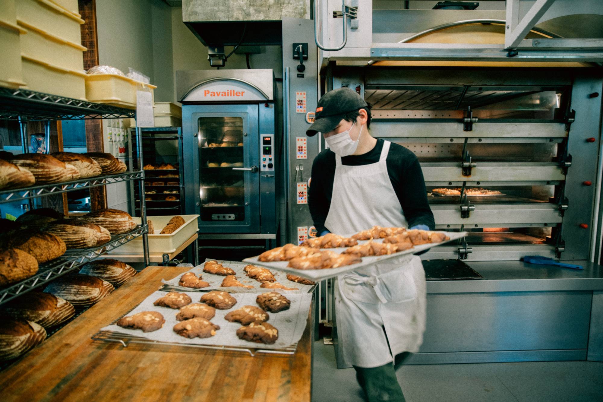 Staff take baked goods out of the oven at Bricolage Bread & Co. in Roppongi. | NATHALIE CANTACUZINO 