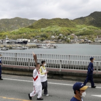 A torchbearer for the Tokyo Olympics runs in Kagawa Prefecture on Sunday. | KYODO