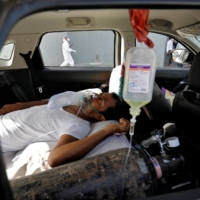 A patient with breathing problems waits to enter a COVID-19 hospital for treatment in Ahmedabad, India, on Thursday.  | REUTERS 