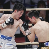 Kenshiro Teraji (left) attacks Tetsuya Hisada during their WBC light flyweight title bout on Saturday in Osaka. | KYODO