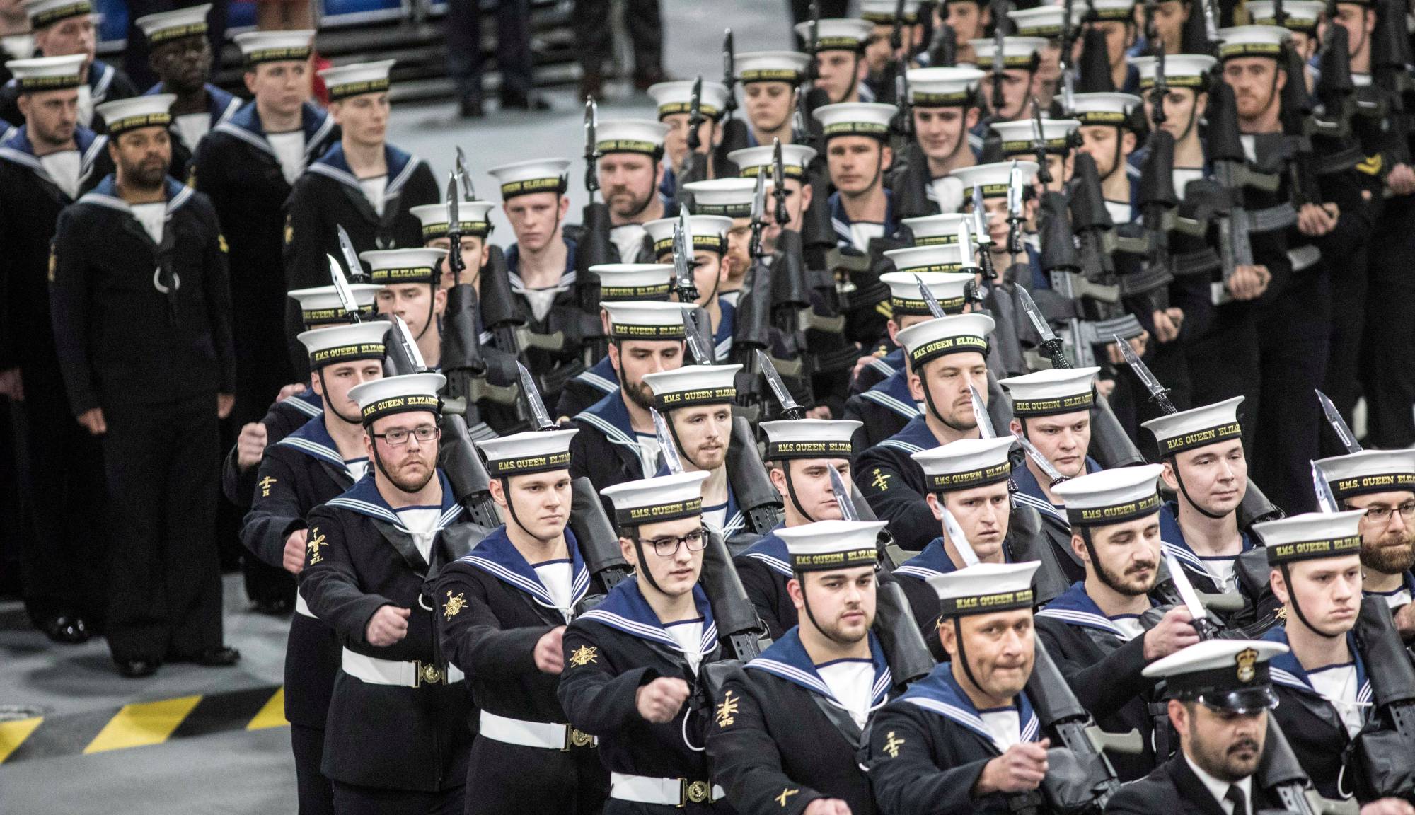 Members of the ship's company attend the commissioning ceremony for the British Navy's aircraft carrier HMS Queen Elizabeth in Portsmouth, England, in December 2017. | POOL / VIA REUTERS 