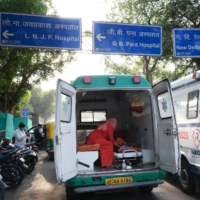 A COVID-19 patient is attended to in ambulance while waiting at the main entrance of the Lok Nayayak Jaiprakash Hospital in New Delhi on Saturday.  | BLOOMBERG 