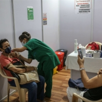 A nurse administers a dose at a vaccination center in Mumbai on Tuesday.  | BLOOMBERG 
