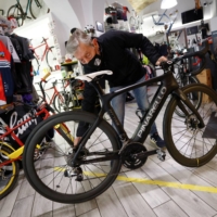 A cycling shop owner displays an electric bike at his shop in Rome. A closer look by environmentalists at the spending plans prepared by Italy raises questions about how green Rome\'s contribution will be to Europe\'s recovery plan.  | REUTERS