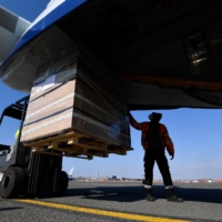 A worker loads medical supplies bound for India at the Oostende-Bruges Airport in Belgium on Friday. | AFP-JIJI
